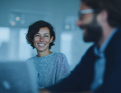 Man and woman in business attire reviewing data on a large digital screen